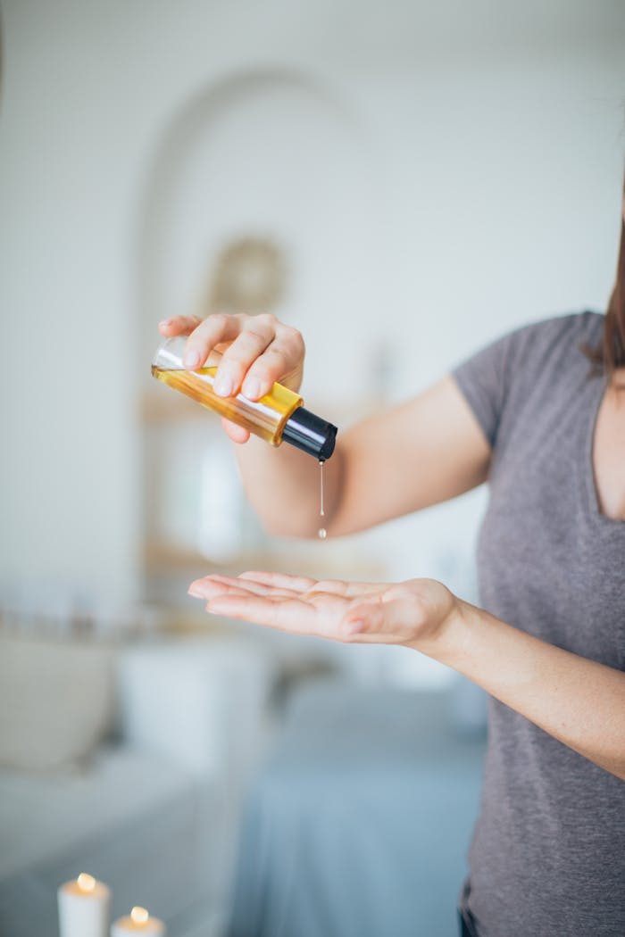 about-bg Close-up of a woman pouring massage oil into her hand in a serene spa setting, promoting relaxation.