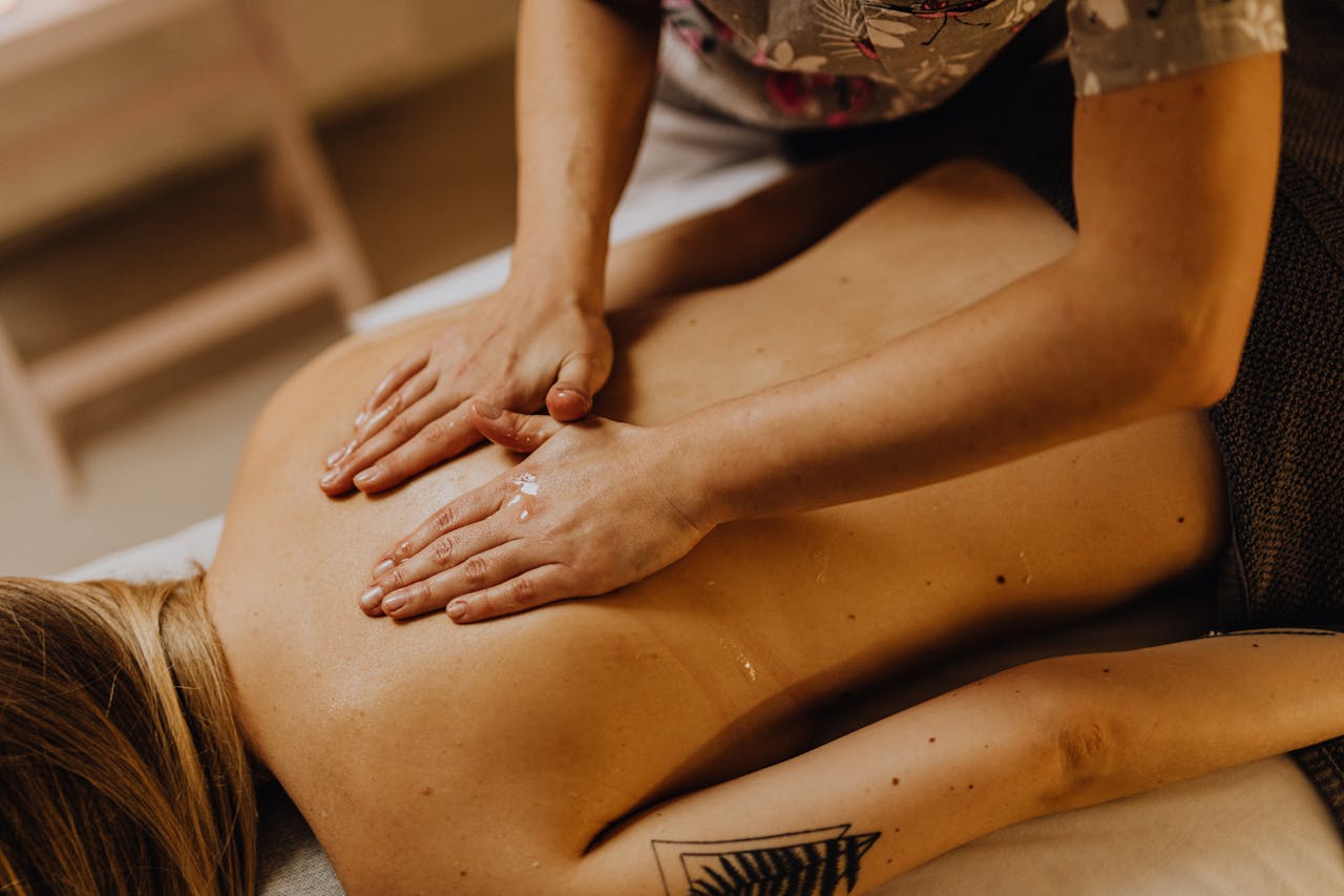 Close-up of a relaxing back massage at a spa with hands applying massage oil.